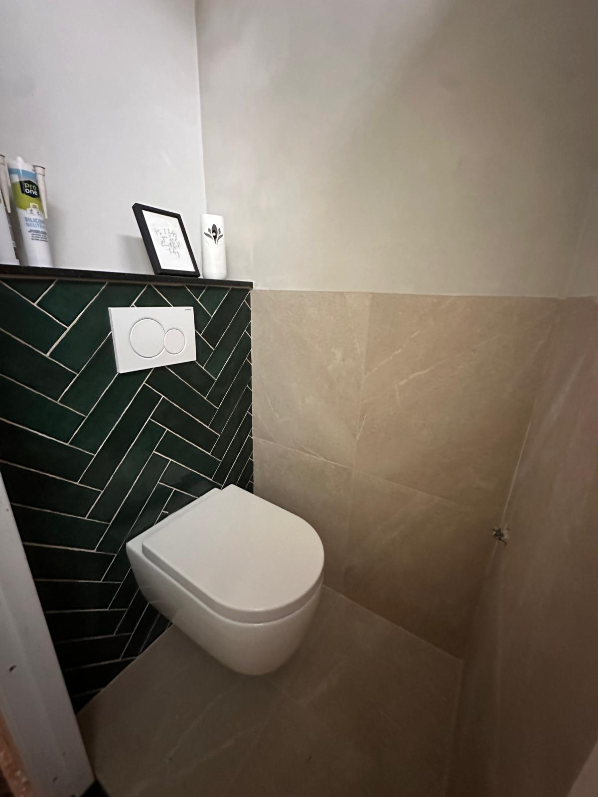 Toilet met groene visgraattegels